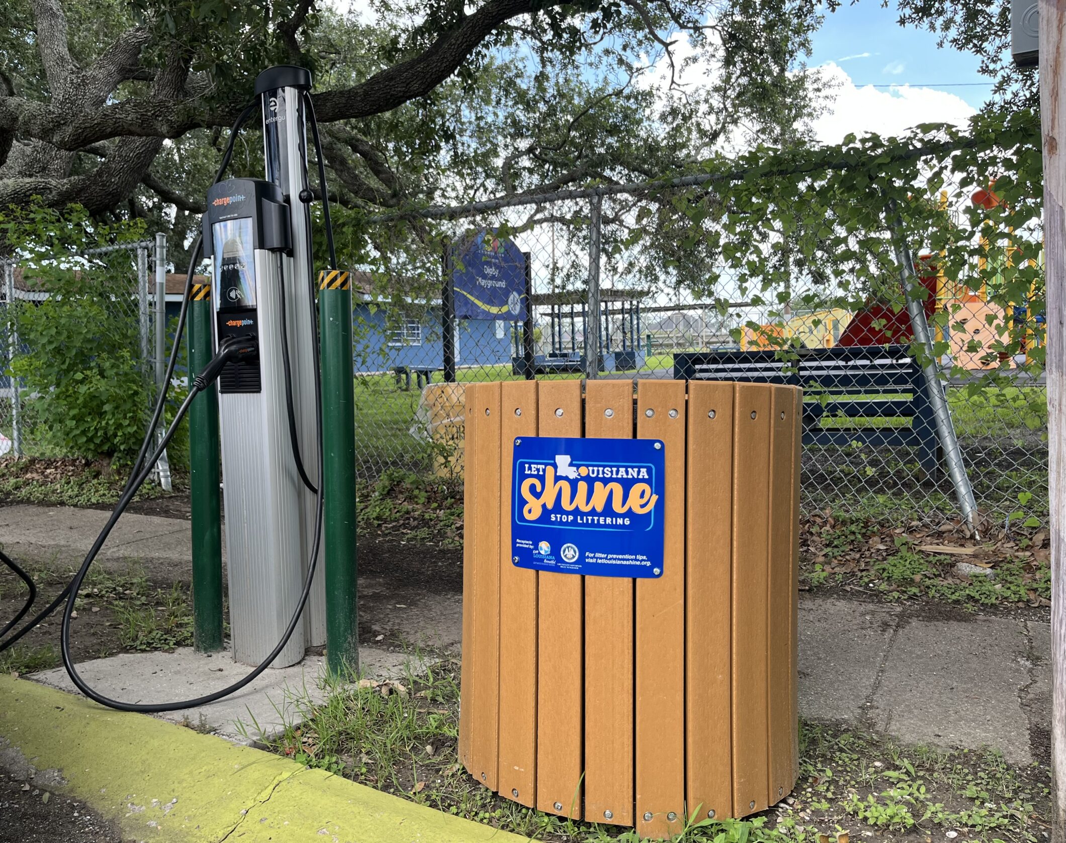 A ChargePoint EV station next to a trash can. A sign on the can reads "Let Louisiana Shine, Stop Littering."