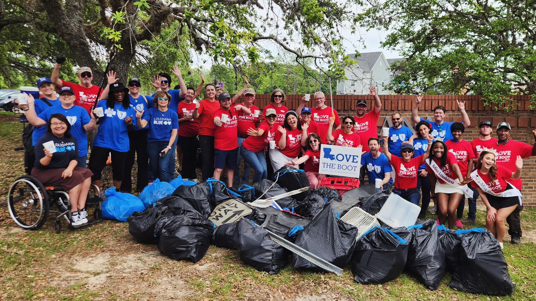People celebrating after a litter pick up. Posing in front of trash collected.