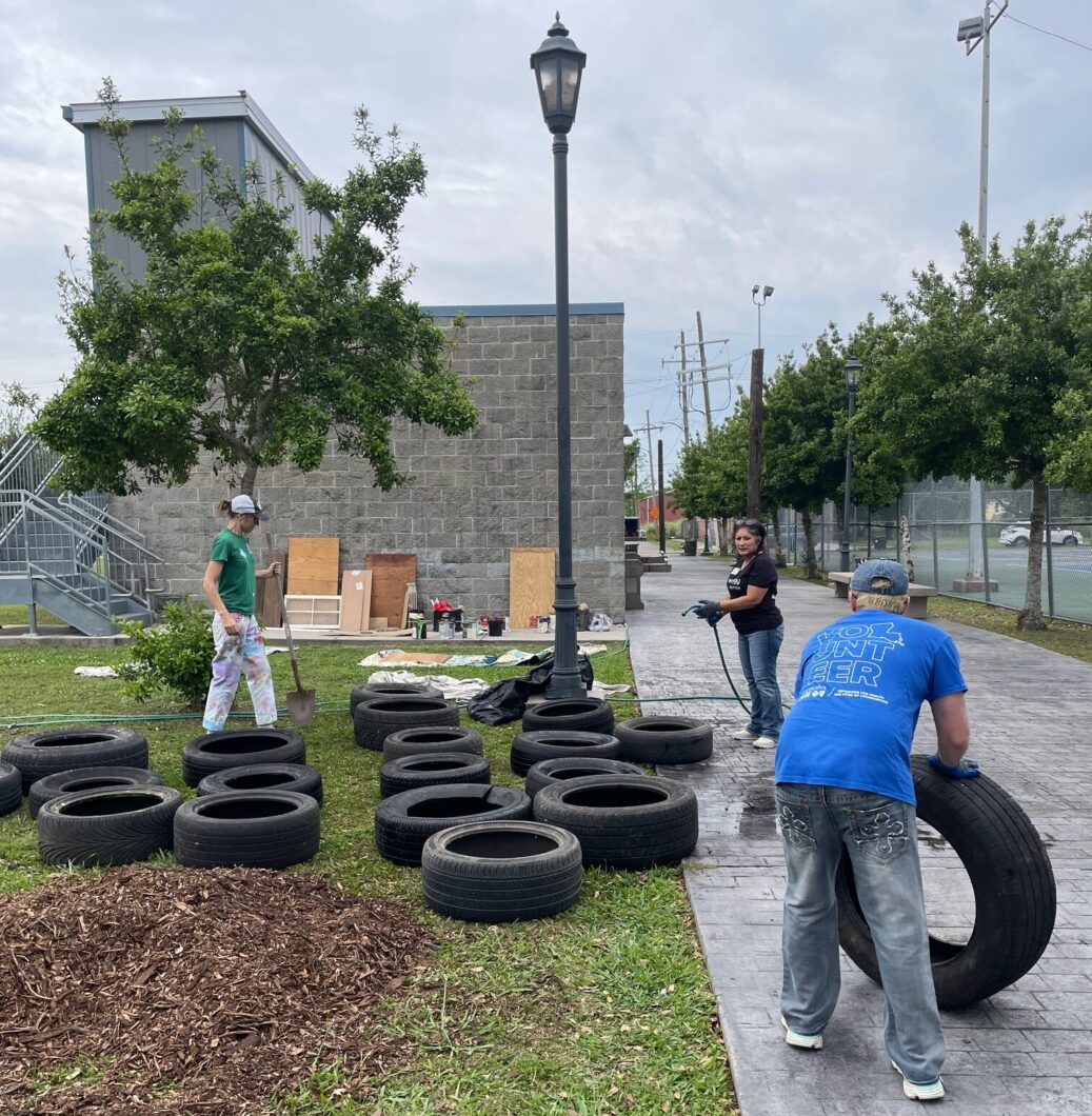 A collection of waste tires being prepped by volunteers for creating planters.